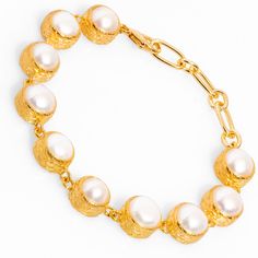 The Vintage Style Pearl Tennis Bracelet, a stunning blend of classic design and modern elegance. This bracelet features 24k gold-plated vintage-inspired settings, each housing a round pearl stone that creates a beautiful, seamless flow. Its timeless charm makes it the perfect accessory for weddings, special events, or to add a touch of elegance to your everyday outfits. The sophisticated design of this pearl tennis bracelet adds a delicate yet luxurious touch, making it a must-have for anyone who appreciates vintage glamour. Details Crafted with high-quality brass and plated with 24k gold for a luxurious finish. Pearl stones Bracelet size 7'' Avoid contact with chemicals, makeup, parfume. Do not use dips or abrasive cleaners on bracelet. To clean and brighten it up your bracelet, wipe them Luxury Gold-tone Jewelry With Pearl Chain, Luxury Gold-tone Pearl Jewelry, Elegant Gold-tone Jewelry With Pearl Charm, Elegant Gold-tone Pearl Jewelry, Luxury Gold-tone Oyster Bracelet, Formal Gold-tone Pearl Jewelry, Classic Gold Bracelet With Pearl Drop, Classic Gold Pearl Drop Bracelet, Classic Gold Bracelets With Pearl Charm