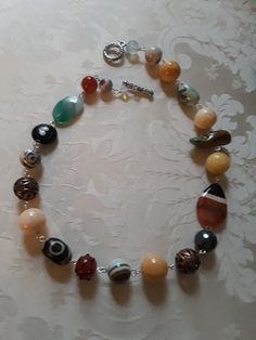 A beautiful assorted gemstone necklace chain linked. Assorted beads are sandstone, carnelian, onyx, jasper, turquoise and other assorted beads. These beautiful beads measure from.12mmm to 18mm.the flat beads measure 35mm by 24mm. A great look for any occasion. Multicolor Beaded Agate Necklaces, Multicolor Agate Large Beaded Necklaces, Agate Gemstone Beads Necklaces, Multicolor Agate Beaded Necklace With Large Beads, Carnelian Jewelry With Colorful Beads For Jewelry Making, Multicolor Large Beads Agate Necklace, Multicolor Natural Stone Beads And Cabochons, Round Agate Necklaces With Gemstone Beads, Agate Gemstone Beads Necklace