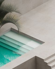 an empty swimming pool in the middle of a building next to a palm tree and stairs