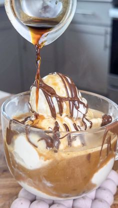 an ice cream sundae is being drizzled with chocolate