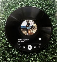 a black record player sitting on top of green plants