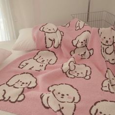 a pink blanket with white dogs on it