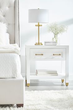 a white bed sitting next to a night stand