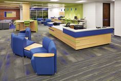 an empty office with blue chairs and desks