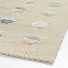 an area rug with different colored circles on the carpet and white background, including blue, gray, pink, green, and beige colors