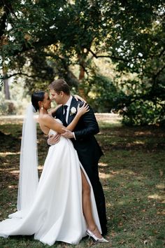 a bride and groom embracing each other in the grass