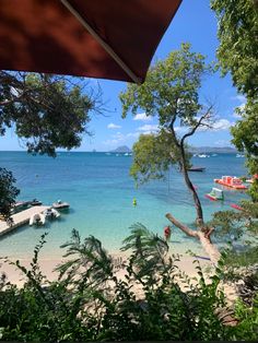 the beach is clear and blue with boats on it's shore in the distance