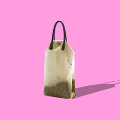 a white bag with black handles on a pink background