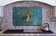 a painting on the wall above a stove with a teal background and gold tree