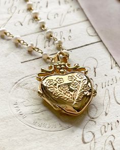 The Jardin Luxe Locket, my love locket is a beautiful locket you can keep your treasures close to the heart. Gold plated silver functioning heart locket and possible to adhere photo 5/8"x5/8" inches. Gold plated silver pearl rosary chain chain 20 inches in length. All items come in a gift box ready to gift. To see more please visit my Etsy shop at https://www.etsy.com/shop/BijouLimon How to add photo- use the closed locket as a template for the photo you want to use. You will need to cut the pho Love Locket, Locket Gold, Locket Jewelry, Pearl Rosary, Christmas Wedding Gifts, Latest Jewellery Trends, Chain Making, Heart Locket Necklace, Jewelry Lockets