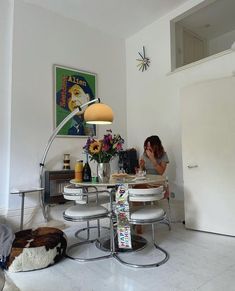 a woman sitting at a table with food in front of her and a lamp on the wall