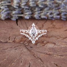 an engagement ring sitting on top of a piece of wood with lavender flowers in the background