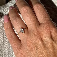 a woman's hand with a diamond ring on it