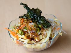 a glass bowl filled with food on top of a wooden table