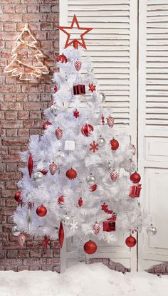 a white christmas tree with red and silver ornaments