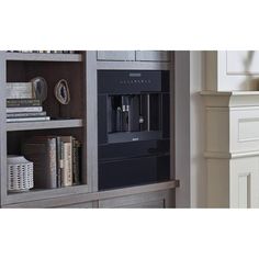 a book shelf with some books on it and a coffee maker in the middle of it