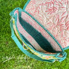 a pink and blue bag sitting on top of green grass