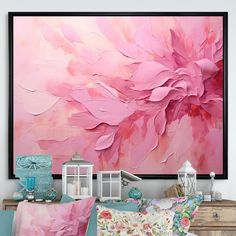 a large pink flower painting hanging on the wall above a bed with pillows and blankets