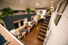 an overhead view of a living room and kitchen area with stairs leading up to the second floor