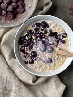 a bowl of oatmeal with blueberries and raspberries in it