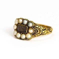 This lovely example of a late Georgian mourning ring holds a weave of hair behind crystal which sits on the most beautiful shoulders. The shoulders feature a raised flower pattern and the ring is modelled out of 9ct gold.Ring Size: M 1/2 or 6 1/4 Antique Open Ring Wedding Jewelry, Antique Open Ring Jewelry For Wedding, Victorian Cabochon Jewelry For Memorial, Victorian Cabochon Wedding Rings, Victorian Gold Moonstone Wedding Ring, Victorian Memorial Jewelry Ring, Vintage Intricate Design Jewelry For Memorial, Victorian Cabochon Jewelry For Wedding, Victorian Open Ring Jewelry For Anniversary