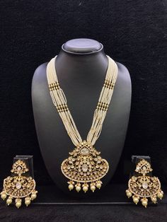 All our pieces are in stock and will be dispatched within 24 to 48 hours of order. Orders received during the weekend will be dispatched on Monday The pearl strings on both sides of an elegant Kundan pendant make it a statement wedding necklace. One of our favorite picks for the wedding season 2022❤️ The drop length of the necklace: is approximately 11 inches, and comes with an adjustable string. Length of Earrings: 2 inches Ornate Pendant Jewelry For Wedding, White Kundan Jewelry For Jewelry Making, Ornate Heavy Jewelry Sets For Gift, Antique Pendant Jewelry For Wedding, Handmade Gold Kundan Necklace For Wedding, Ornate Kundan Pendant Necklace For Wedding, Kundan Pearl Pendant Necklace For Wedding, Heavy Pendant Necklace For Wedding, Tilla Pendant Bridal Necklace For Wedding