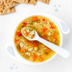 a white bowl filled with soup next to crackers