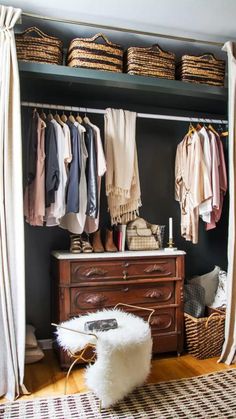 an open closet with clothes hanging on the wall and wicker baskets in front of it