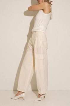 Loosely tailored cargo pant in a soft yet structured cotton. Straight leg with tie at ankle, cinch for a more tapered silhouette. Side pockets and oversized patch pockets above knee. Made in New York City. Fabric is 100% cotton. Ella is 6' tall, 35" bust, 26" waist, 36" hip, and is wearing a size S. Spring Cotton Cargo Pants With Cargo Pockets, Spring Cotton Cargo Pants With Side Pockets, Cotton Straight Cargo Pants, Workwear Straight Parachute Pants With Flap Pockets, Workwear Parachute Pants With Flap Pockets, Cotton Parachute Pants With Side Pockets For Spring, Spring Workwear Cargo Jeans, Utility Cotton High-waisted Parachute Pants, Spring Cotton Cargo Pants For Workwear