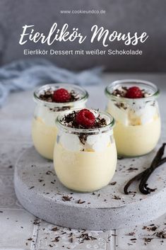 three desserts in small glass jars with raspberries on top