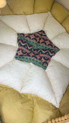 a square pillow on top of a round bed