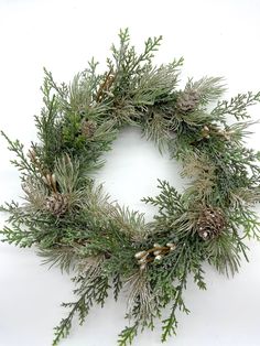 a wreath with pine cones and evergreen needles