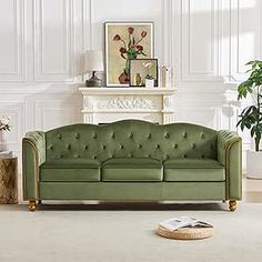 a living room with a green couch and white walls