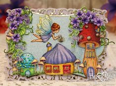 a card with an image of a fairy holding a potted plant and mushroom house