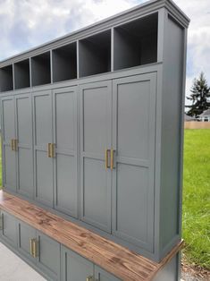 a large gray cabinet sitting on top of a wooden bench