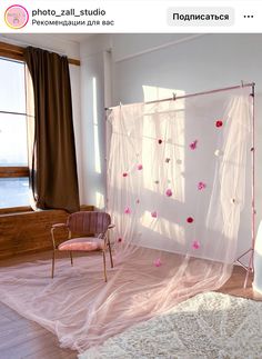 a room with sheer curtains and flowers on the wall