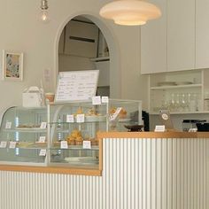 a bakery counter with pastries on display in it's glass case and lights above the counter