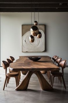 a wooden table with chairs around it in front of a painting on the wall above