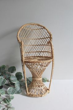 a wicker chair sitting on top of a table next to a potted plant