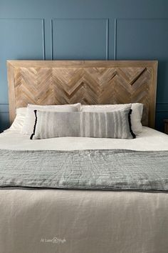 a bed with two pillows on top of it and a headboard made out of wood