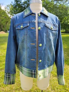 a blue jean jacket sitting on top of a mannequin's head in the grass