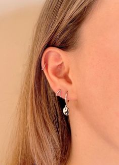 a close up of a woman's ear with earrings on her left and right side