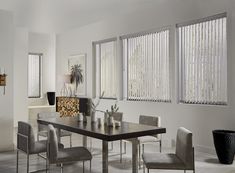 a dining room table and chairs with blinds on the windows