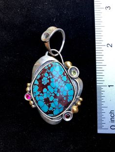 "Prince Turquoise gemstone pendant Hand-made Sterling Silver 925, 24k Gold Stones used: Prince Turquoise, Garnet, Peridot, Cubic Zirconia Height - 2 1/2\" (with bail), Width - 1 3/8\" Height -60mm (with bail), Width - 35mm Unique Handcrafted One-of a-kind Design Pendant Each Piece of Jewelry in my Collection is Absolutely One of a Kind! When you start wearing a piece of my jewelry you will fall in love with it more and more each day and feel that good Energy and Love that I pass into it while cr Elegant Turquoise Pendant Necklace With Large Stone, Spiritual Jewelry With Large Stone Pendant, Spiritual Pendant Jewelry With Large Stone, Spiritual Large Stone Pendant Jewelry, Gold Turquoise Pendant Necklace In Sterling Silver, Fusion Style Turquoise Sterling Silver Jewelry, Fusion Style Sterling Silver Jewelry With Stone Setting, Unique Blue Rectangular Pendant Jewelry, Turquoise Sterling Silver Pendant Gemstone