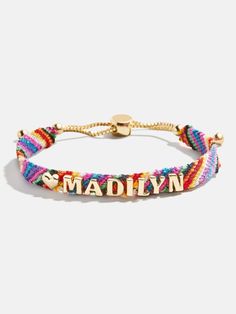 a multicolored bracelet with the word madison on it and gold plated clasp