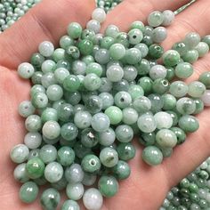 a person holding some green beads in their hand