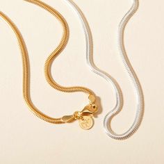 Embrace the elegance of our Snake Chain Necklace, a staple piece to add sophistication to every look. Perfect for wearing alone or for layering alongside your favourite Merci Maman personalized necklaces, this chain is a timeless way to elevate your everyday jewelry collection.&nbsp;18K Champagne Gold Plated or 925 Sterling SilverLength: 0.4Width: 0.09Thickness: 0.05Sent with love in a complimentary gift box Elegant Sterling Silver Charm Necklace With Snake Chain, Timeless Charm Necklace With Adjustable Chain For Everyday, Dainty White Gold Chain Necklace With Round Pendant, Minimalist White Gold Necklace With Gold Chain, White Gold Plated Adjustable Chain Necklace, Classic Chain Necklace With Initial Pendant, Gold Sterling Silver Snake Chain Charm Necklace, Silver Charm Necklaces With Gold Chain In Dainty Style, Sterling Silver Adjustable Initial Pendant Necklace