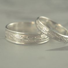 two silver wedding rings sitting next to each other