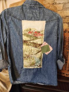 an old jean jacket with a painting on it and a flag hanging from the back