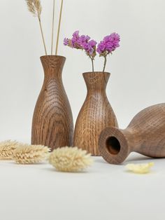 three wooden vases with purple flowers in them